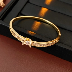 Macro detail of gold plated oval bangle with pavé micro zircons and round center diamond