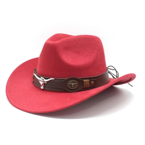 Détail d'un chapeau de cow-boy rouge avec bande en cuir brun et ornement tête de taureau