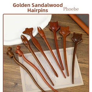 Detail of handcrafted Phoebe wood hairpins featuring intricate cat and fox carvings