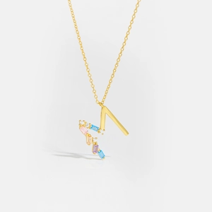 Close-up of golden S925 silver necklace featuring a letter M pendant with colorful zircons