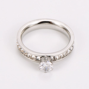 Macro shot of silver six-prong set round solitaire ring with pave diamond band