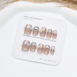 Handmade cat eye press-on nails set with 3D daisies and pearls on a white display tray