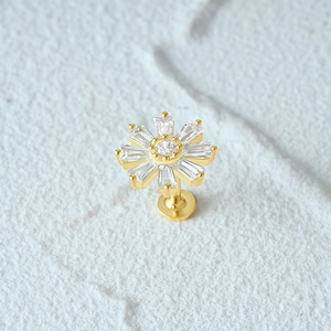 Macro view of a gold S925 silver ear stud featuring a flower design with trapezoid gems