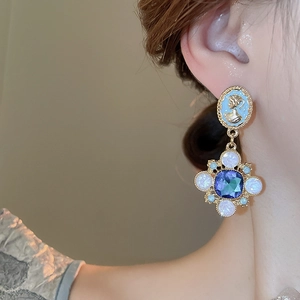 Gros plan de boucles d'oreilles camée vintage avec pendentif en cristal bleu