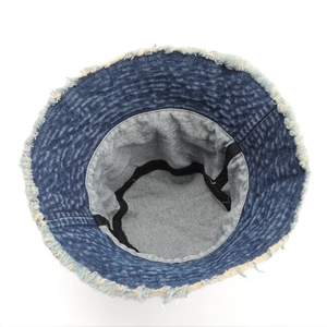 Detail shot of denim bucket hat showing raw fringe edges and inner black sweatband