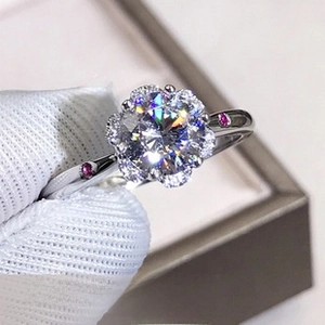 Macro shot of a floral moissanite ring with pink accent stones and white gold finish