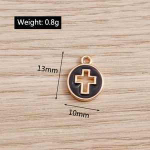 Macro detail of 13mm gold and black enamel hollow cross pendant charm for jewelry