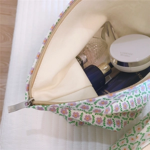 Detailed view of floral canvas makeup bag showing interior storage and zipper quality