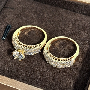Detailed macro view of two-piece luxury gold ring set with round zircon in a jewelry box