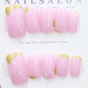 Pink marble reusable press-on nails with gold glitter accents and white texture