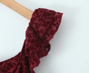 Close-up of burgundy tiered ruffles and flocked mesh fabric on a sleeveless dress
