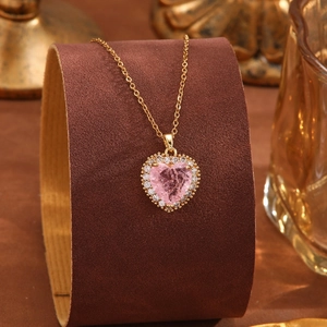 Exquisite Halskette mit rosa Herz-Kristallanhänger und Goldkette auf einem Ständer