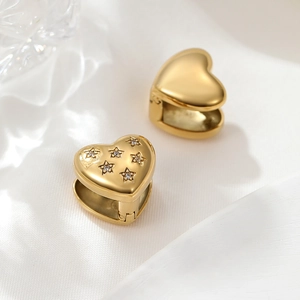 Detailed macro of gold heart hoop earrings with asymmetrical sparkling star zirconia