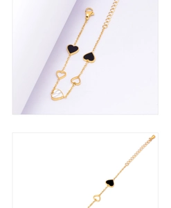 Detail of gold heart bracelet featuring black inlay, hollow motifs and white mother of pearl