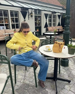 Outdoor street style photo of women's yellow tweed jacket with blue wide-leg jeans