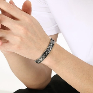 Close-up of vintage silver viking cuff bracelet with embossed nordic triangle symbols