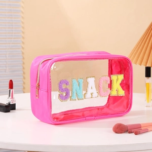 Detailed view of pink transparent PVC travel bag with SNACK towel embroidery and zipper