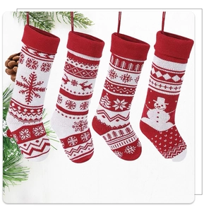 Detailed view of four red and white knitted Christmas stockings with festive patterns