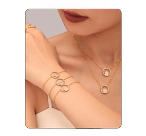 Détails de colliers et bracelets dorés avec pendentifs ronds en zircons portés par un modèle
