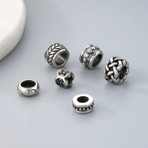 Macro shot of stainless steel cylinder beads with diverse vintage engraved patterns