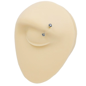 Pair of black zircon eyebrow rings on a realistic silicone eye model for display
