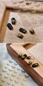 Detail of liquid gold tassel nail stickers with luxury 3D texture on black gradient nails