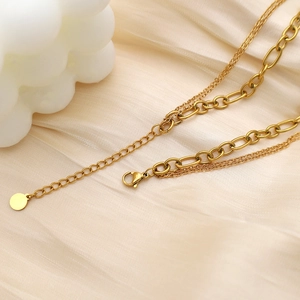 Detail of gold layered chain with lobster clasp and adjustable extender on silk fabric