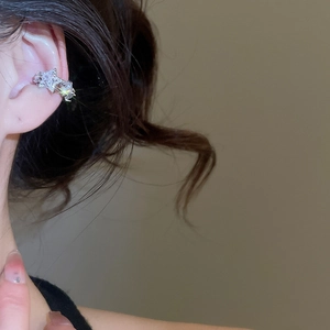 Macro shot of a silver star ear cuff featuring sparkling cubic zirconia on an ear
