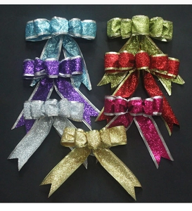 Close-up of seven glitter ribbon bows in various colors for Christmas tree decoration