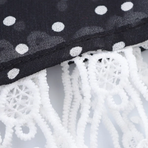 Polka dot mesh dress fabric with elegant white lace tassel trim and detailed stitching
