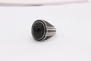 Gros plan détaillé d'une bague vintage en acier pour homme avec une grande pierre noire ovale