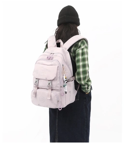 Pink waterproof nylon school backpack with multiple compartments and a cute plush charm