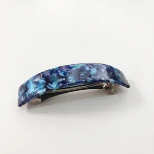 Macro view of blue leopard print acetate hair barrette showing curved spring clip detail