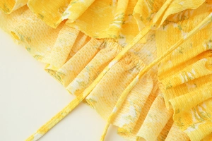 Close-up of yellow floral blouse showing ruffled layers and textured crinkle fabric
