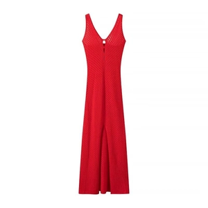 Détail d'une robe rouge en maille avec col en V, tissage texturé et fente sur le devant