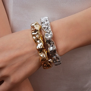 Close-up of gold and silver irregular lava texture acrylic open bangles on wrist