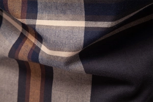 Gros plan macro sur la texture du tissu en coton à carreaux bleus et marrons de qualité