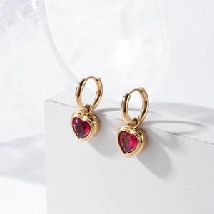 Elegant gold-plated heart earrings with red zircon stones on a geometric base