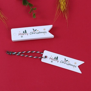 Dettaglio di etichette regalo natalizie a forma di gagliardetto con stampa Merry Christmas