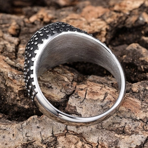 Retro stainless steel rivet ring with black epoxy finish on natural bark background