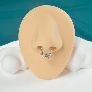 Close-up of silver steel septum ring with wave pattern and clear gem on a nose model