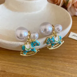 Elegant gold rocking horse earrings with colorful enamel and dual white pearls