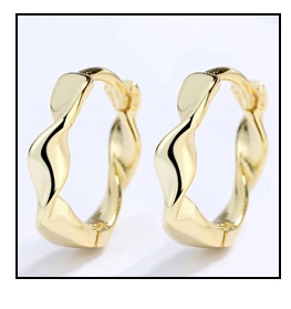 Detail of gold twisted hoop earrings with a modern minimalist wavy geometric design