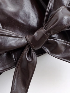 Detail view of the deep brown PU leather waist belt tied in a stylish knot
