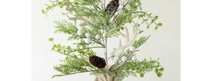 Detail of Christmas cedar branch with white antlers, berries and natural pine cones