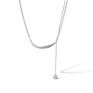 Detail of silver stainless steel necklace featuring crescent tube and sphere pendant