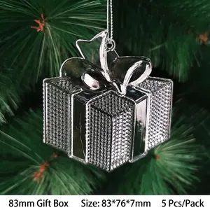 Close-up of clear acrylic gift box ornaments hanging on Christmas tree branches