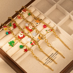 Detailed view of three gold Christmas charm bracelets with Santa and reindeer pendants