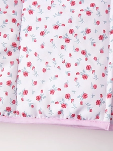 Detailed macro view of pink floral rose pattern on quilted fabric with piping edge