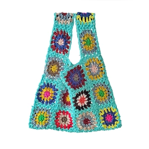 Detailed close-up of handmade crochet tote bag featuring colorful granny square floral patterns